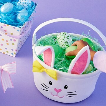white bunny basket with grass and Easter eggs